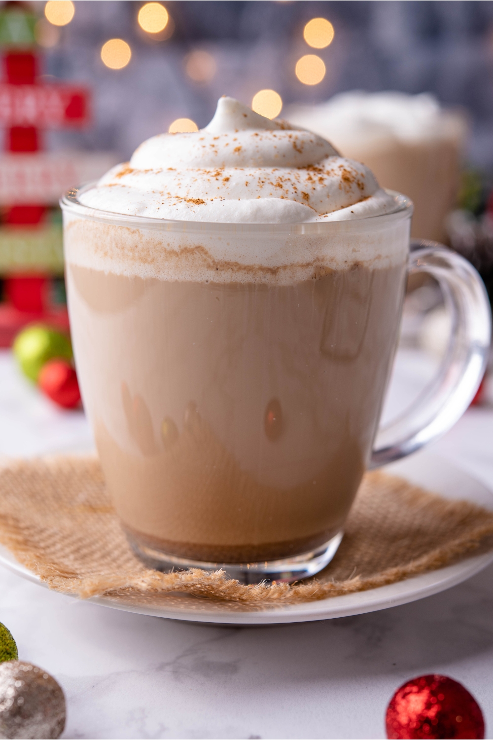 Gingerbread latte in clear mug topped with whipped cream.