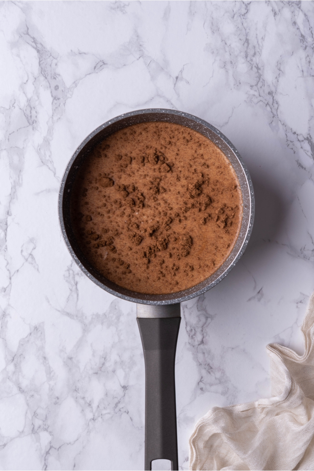 Saucepan filled with milk and dry ingredients for gingerbread lattes.