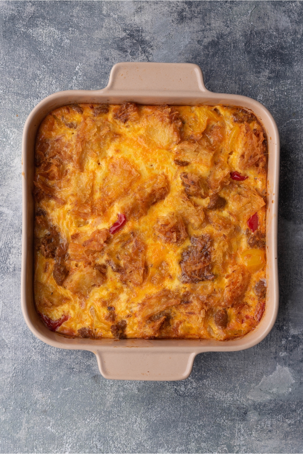 A brown casserole dish with baked sausage casserole.