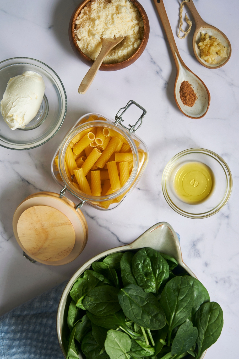 A countertop with the ingredients it takes to make spinach pasta.