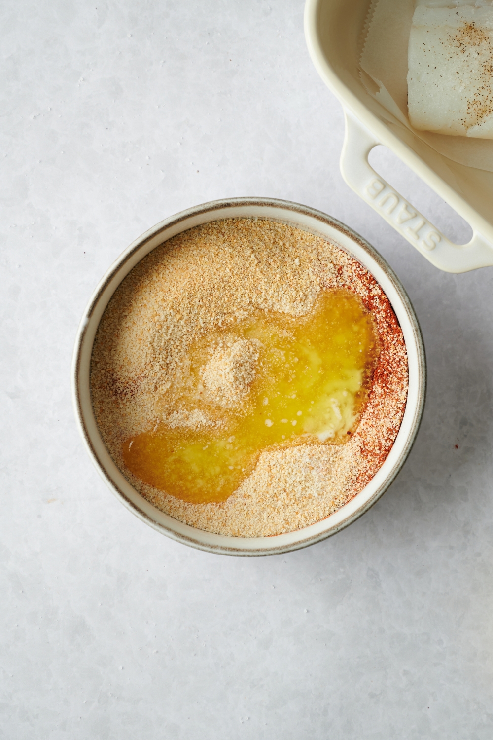 melted butter, bread crumbs, and paprika in a bowl.