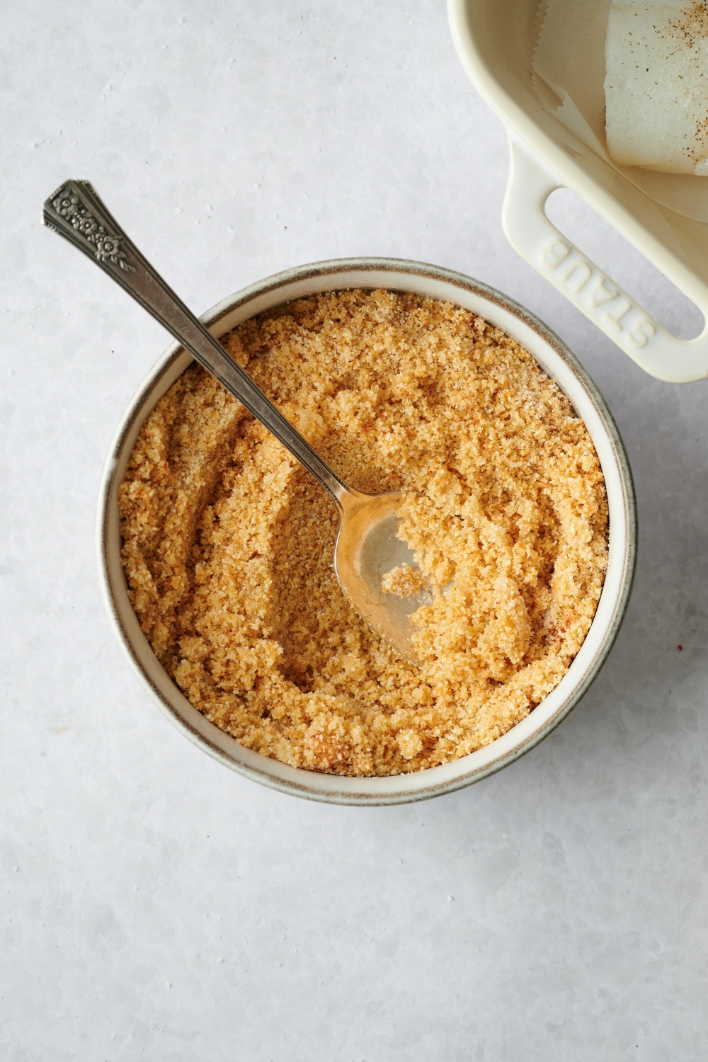 A bread crumb mixture in a bowl with a spoon.