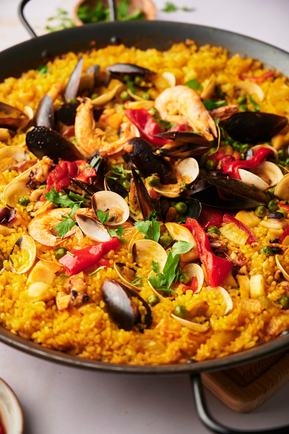 Yellow rice, mussels, and roasted red pepper in a large skillet.