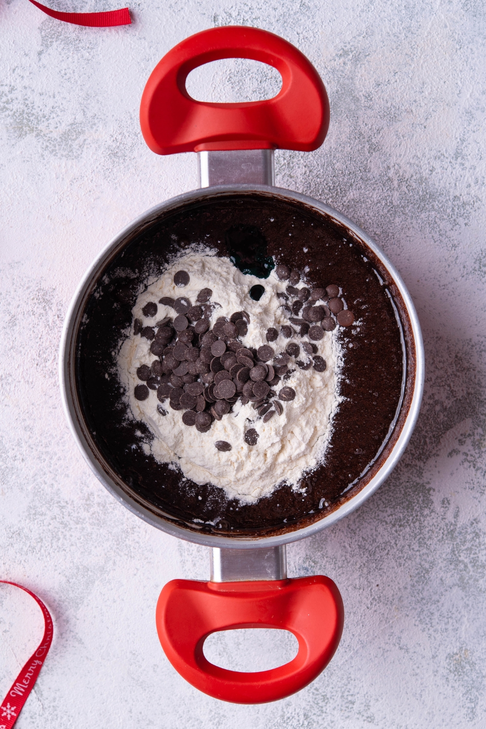 A sauce pot with flour and chocolate chips added to cocoa batter.