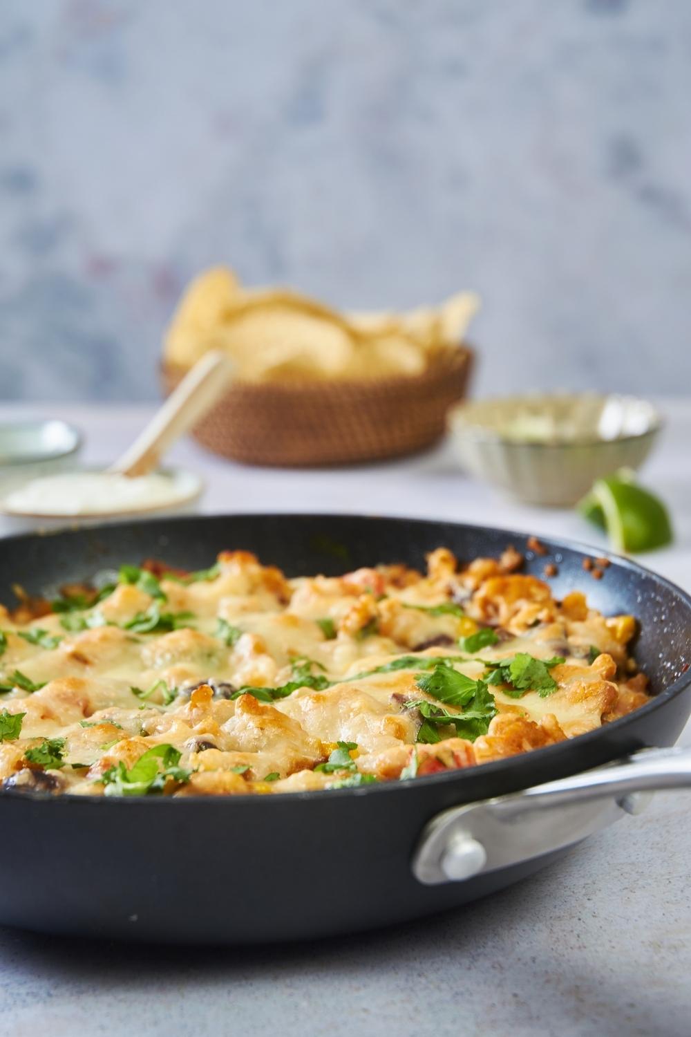 ground turkey casserole in a skillet with topping ingredients in the background