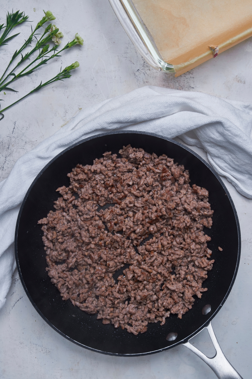 Black skillet filled with cooked ground beef.