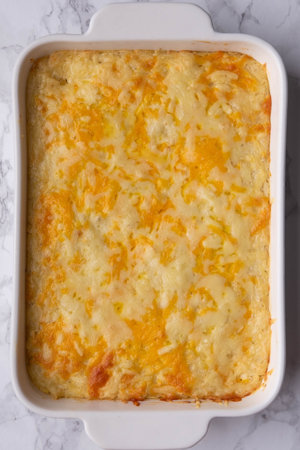 A casserole dish with cooked hash brown casserole in it.