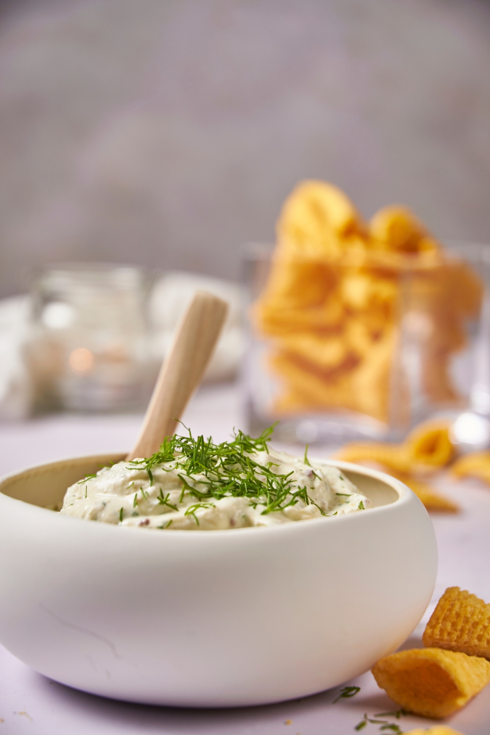 White serving bowl filled with cream cheese dip and a spoon in the dip.