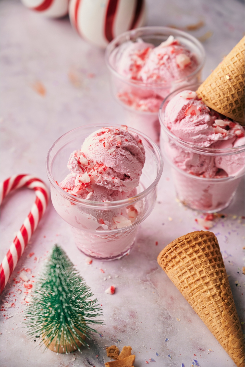 Peppermint ice cream in three serving bowls, one topped with an ice cream cone.