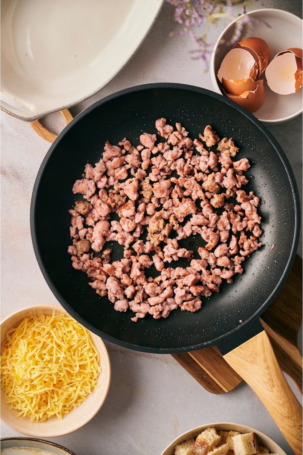 A black skillet with cooked sausage crumbles in the skillet.