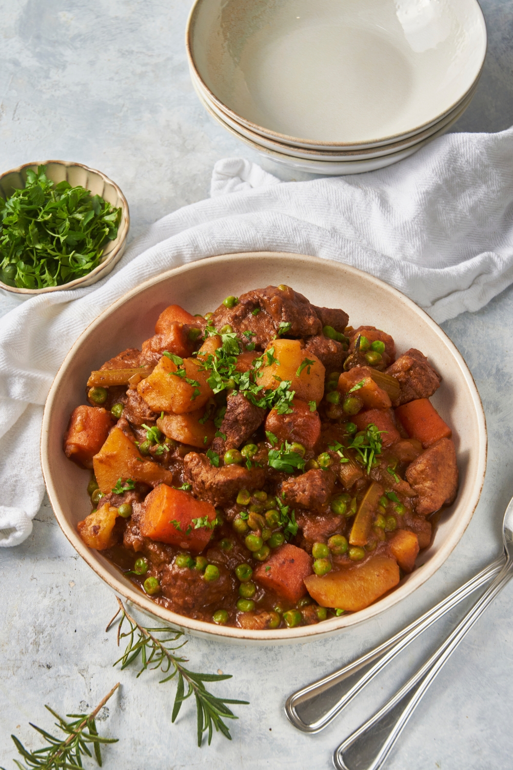 Carrots, potatoes, beef, and peas on a white plate.
