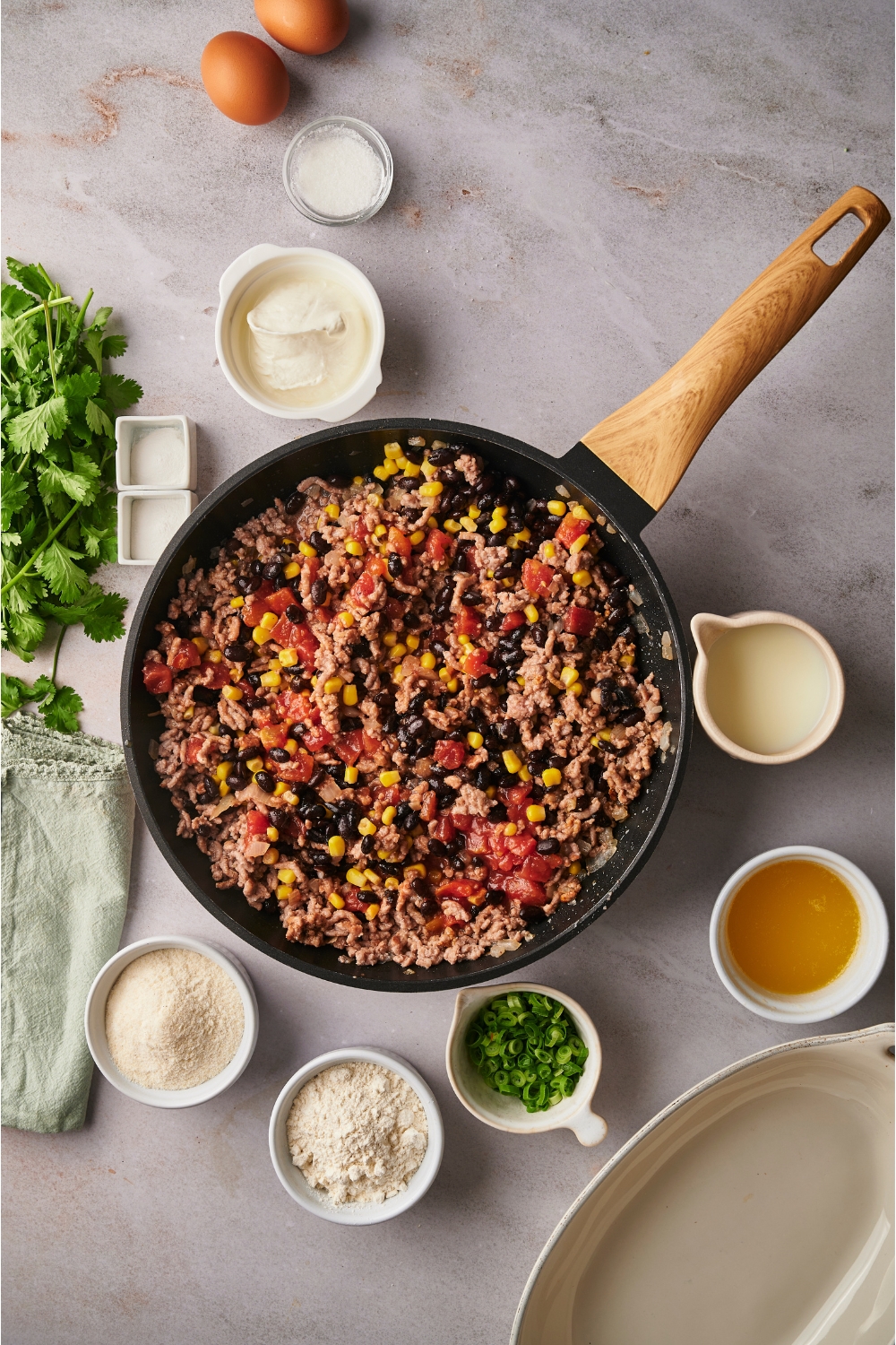 A ground beef mixture with black beans, corn, and tomatoes in a skillet