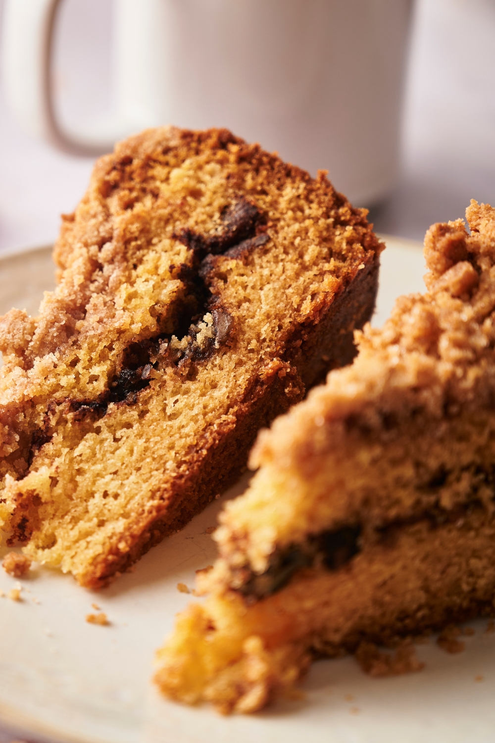 A plate with two slices of coffee cake with crumbly cinnamon sugar topping.