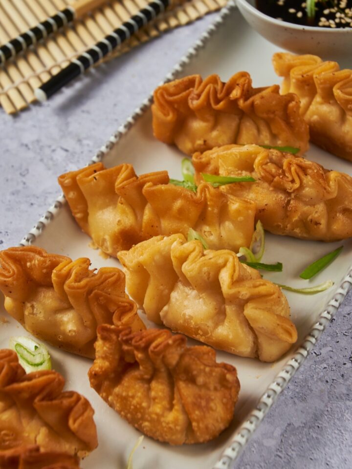 A serving plate with cooked crab rangoon.