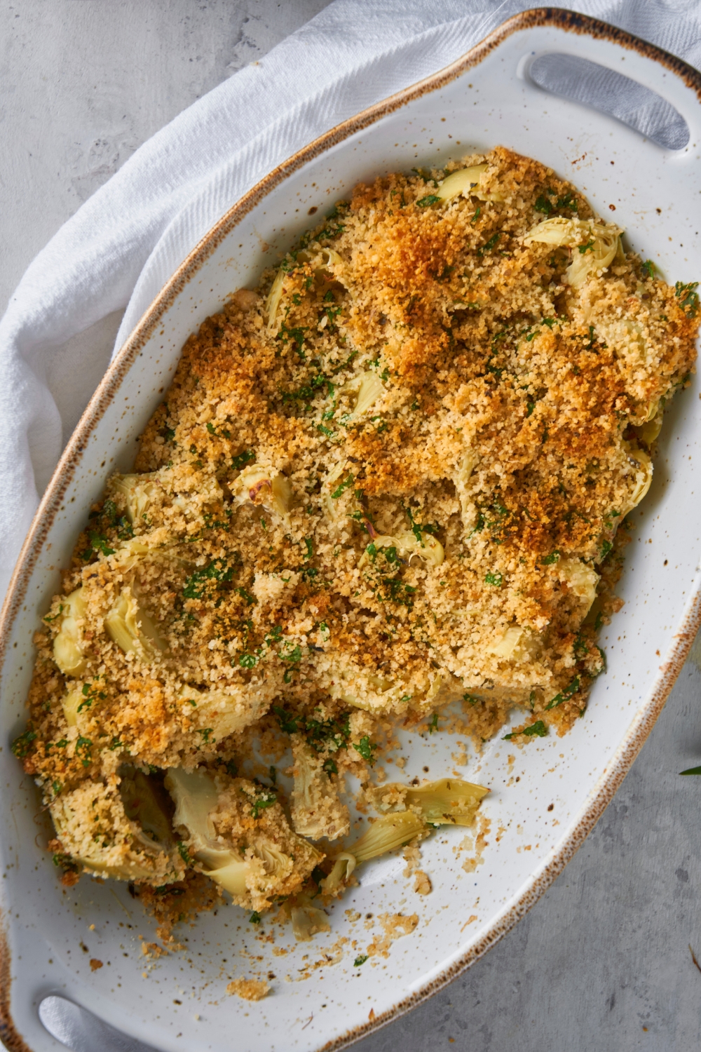 A casserole dish with baked artichoke casserole.