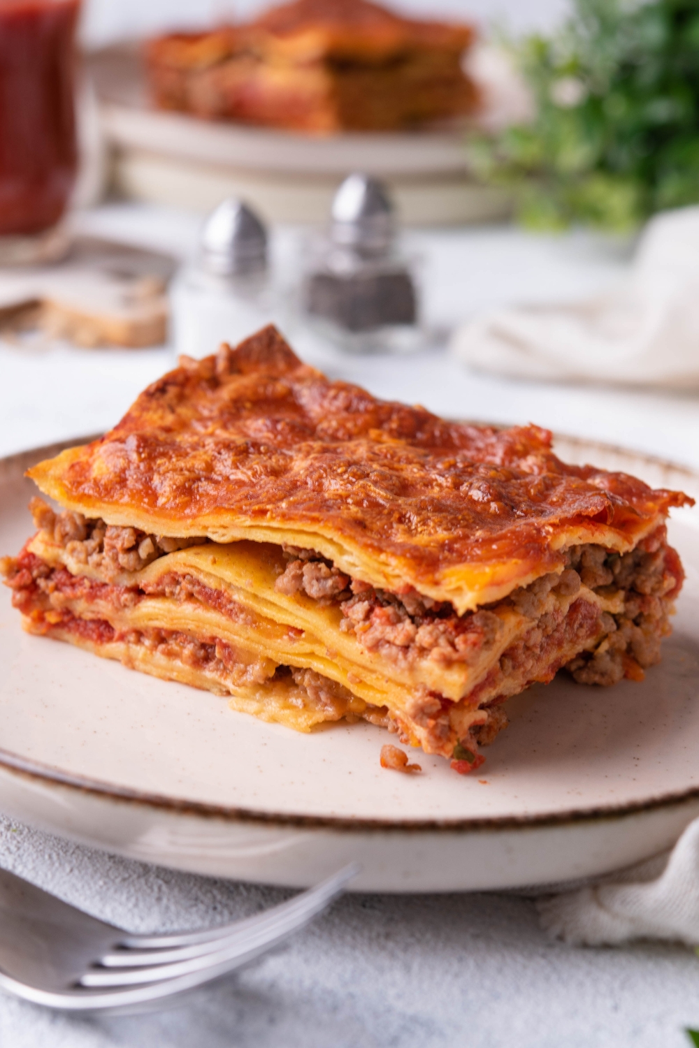 A slice of ground beef enchilada casserole on a white plate.