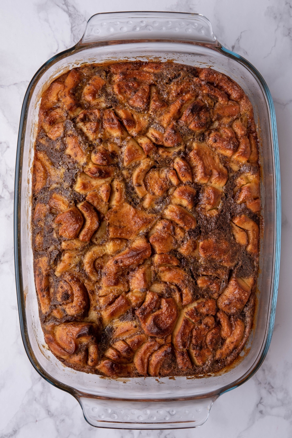 Baked cinnamon roll pieces in a casserole dish.