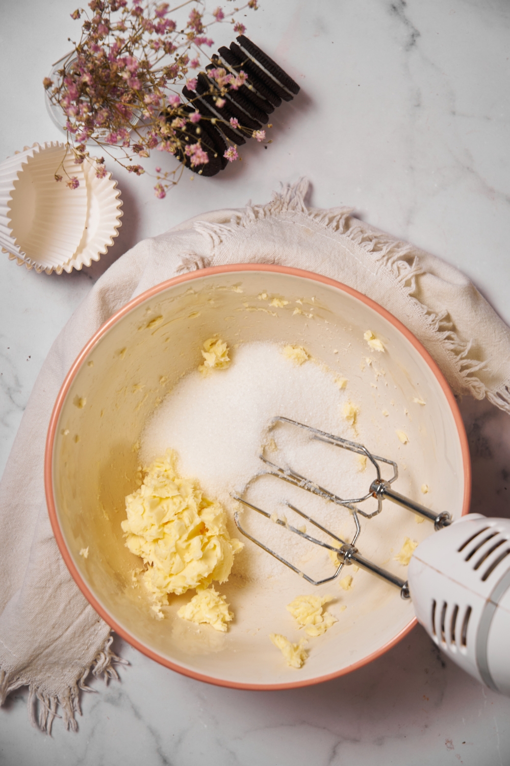 Electric whisk in a bowl with sugar and butter.