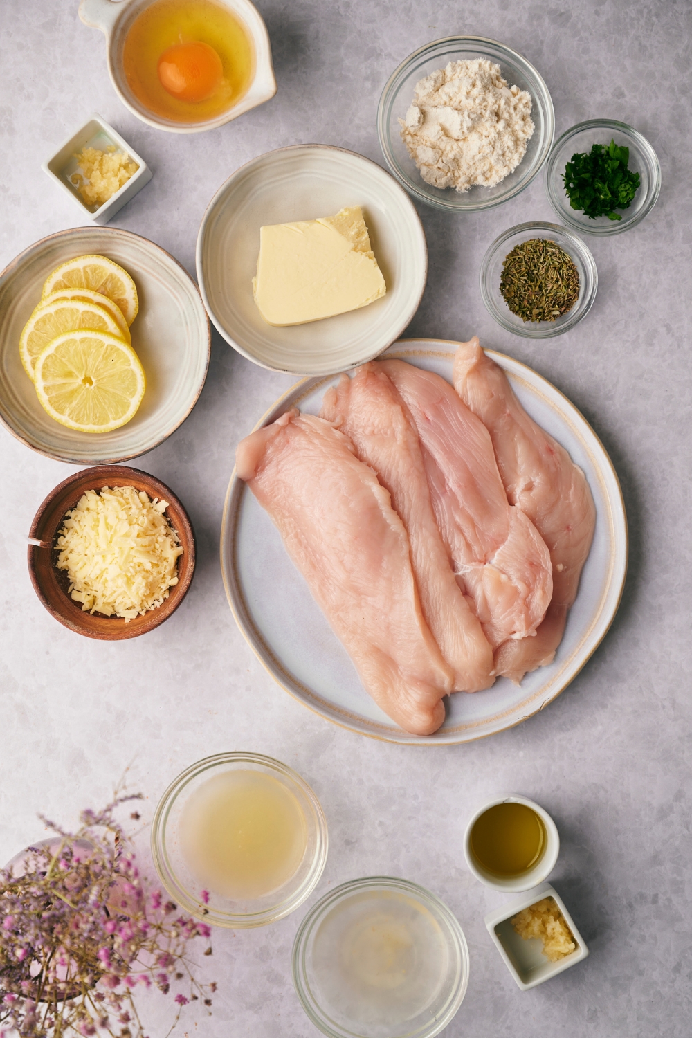 A countertop with multiple bowls with the ingredients to make lemon chicken.
