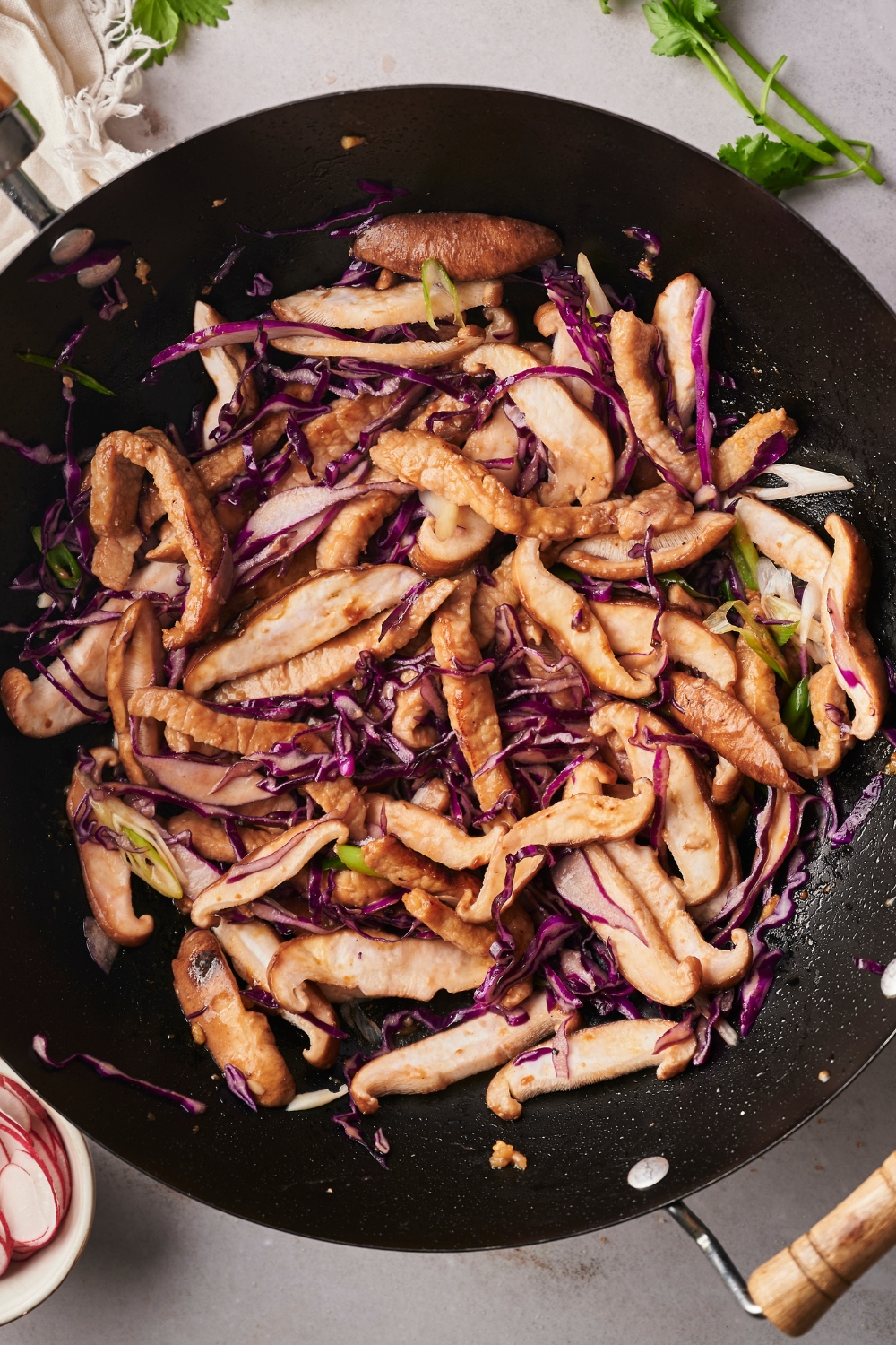 Moo shu pork and shredded purple cabbage in a wok.