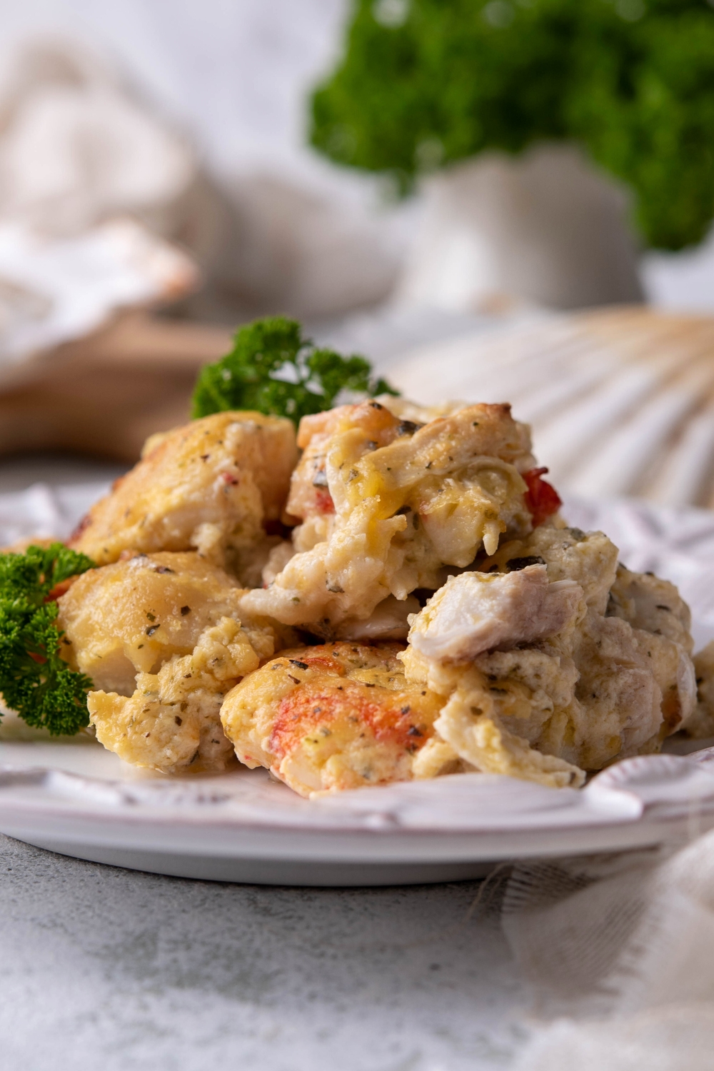 Scallops, crab meat, and shrimp covered in a creamy sauce on a plate.