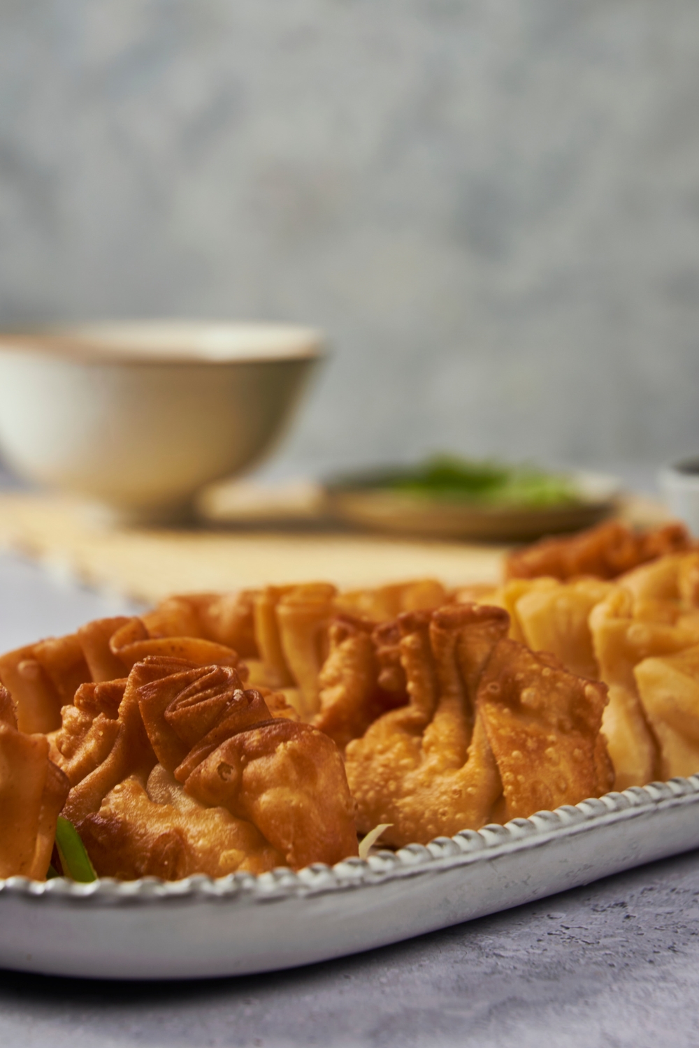 A serving plate with fried crab rangoon.