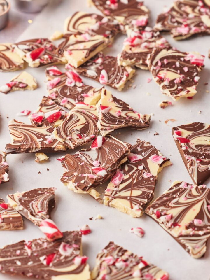 A bunch of pieces of peppermint bark with crushed candy canes on top.