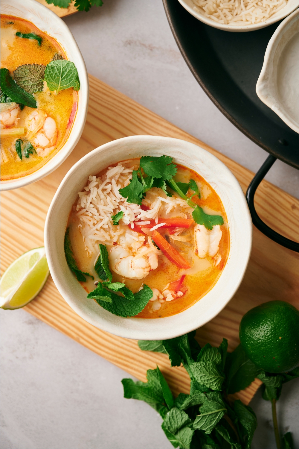 Rice, shrimp, and red bell peppers in a bowl of soup,.