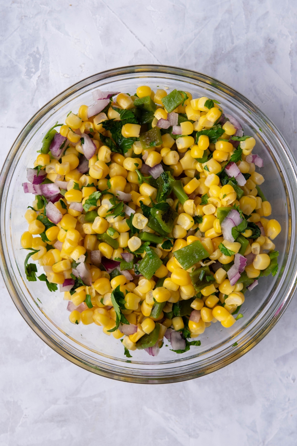 A mixing bowl with corn salsa in it.