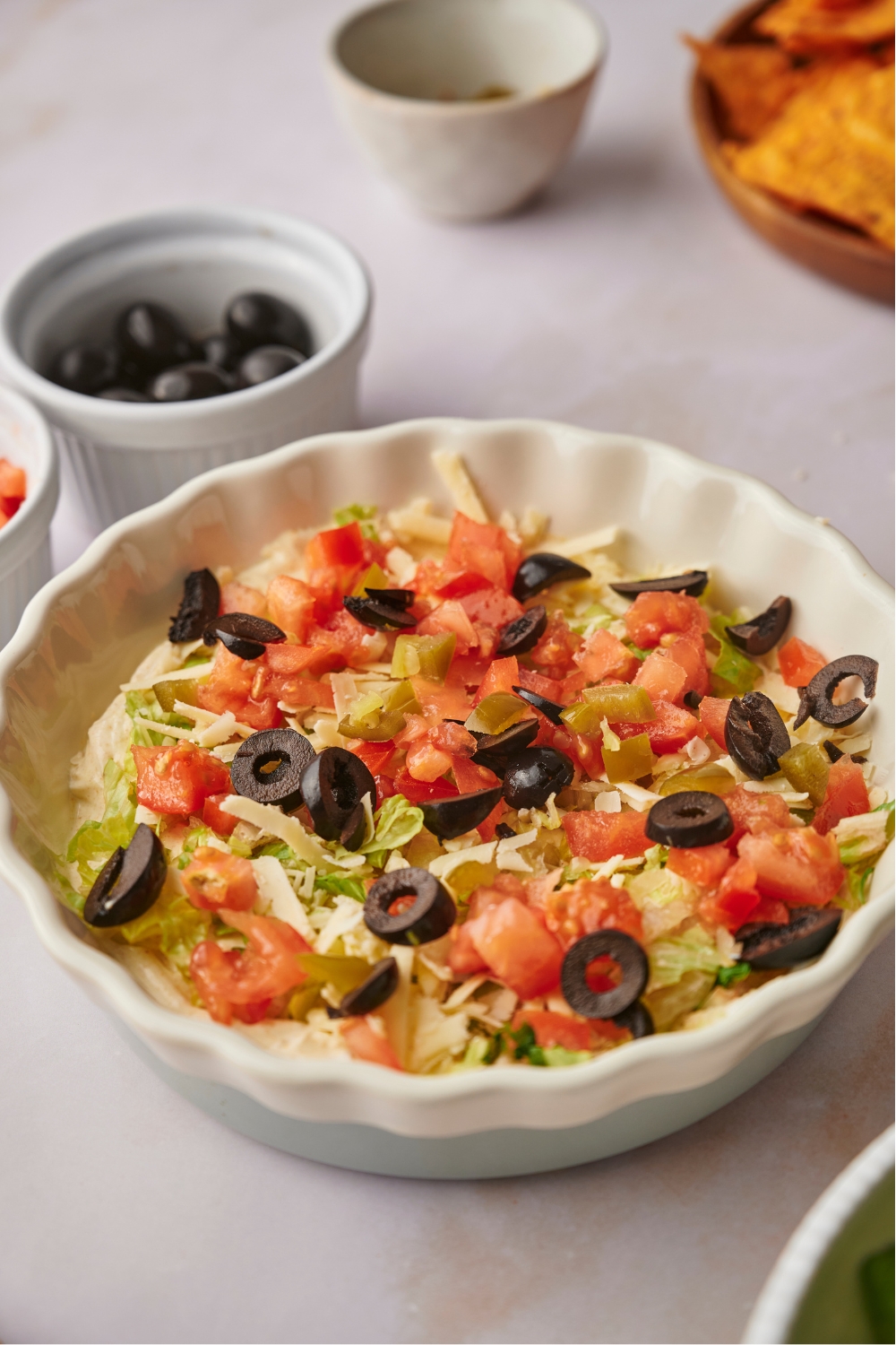 A serving dish with taco dip in it.