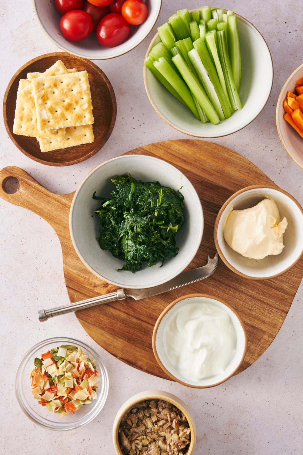 A display of multiple bowl with the ingredients to make Knorr Spinach Dip and dippers for it.