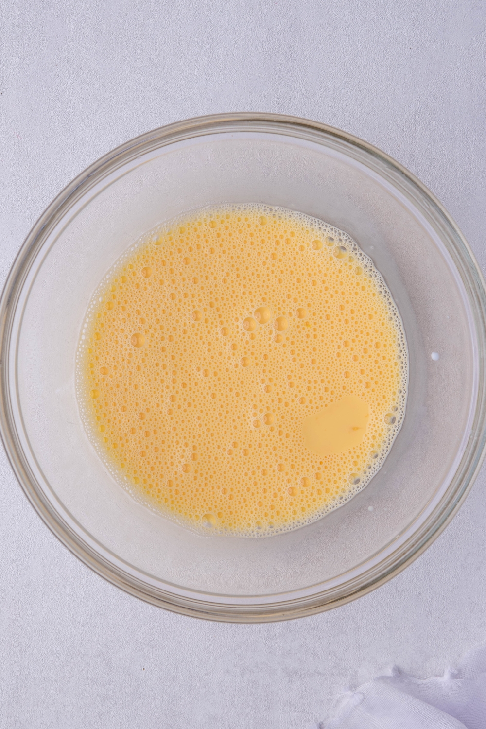 A bowl containing mixed egg yolks and milk.