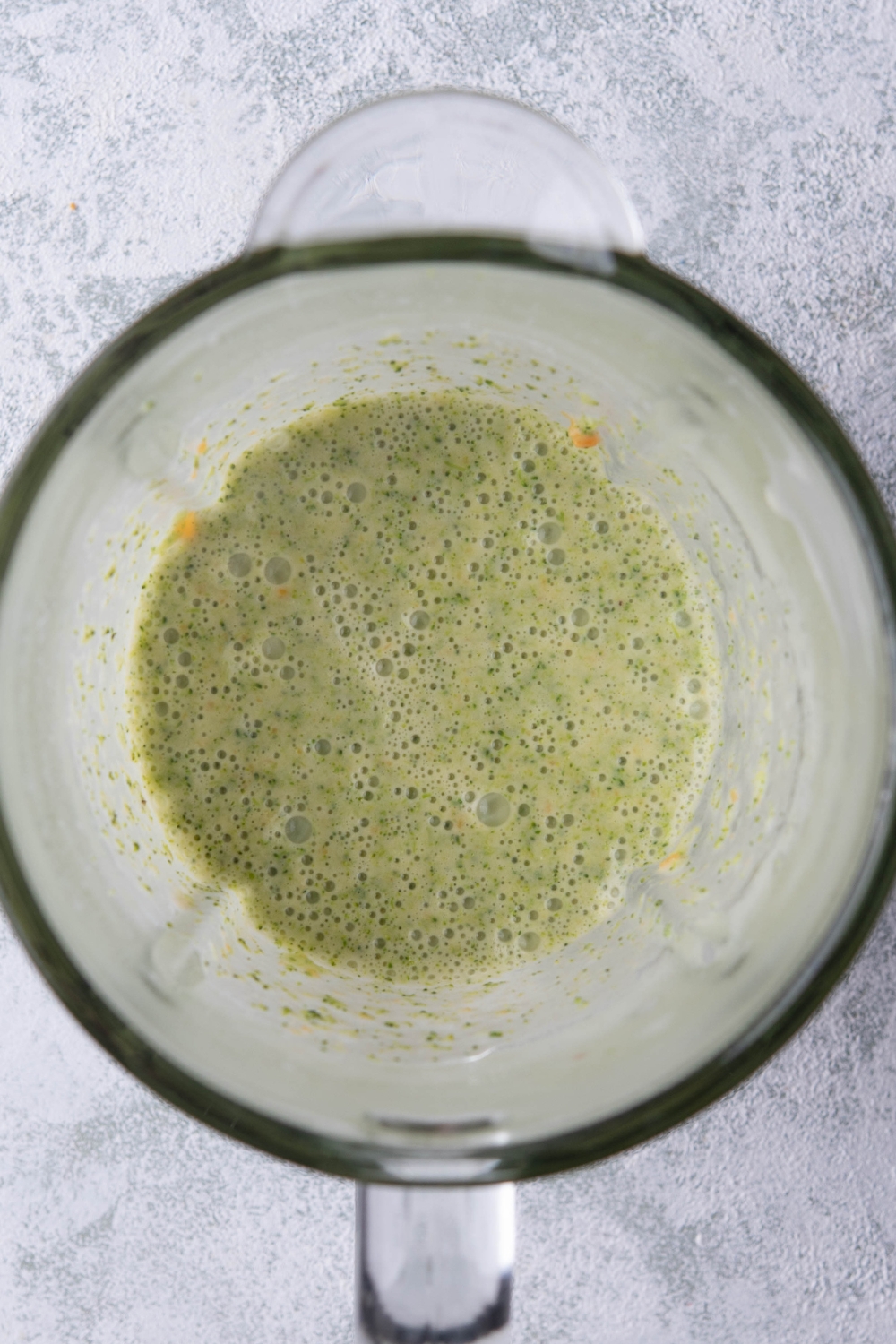 A blender with blended broccoli soup in it.