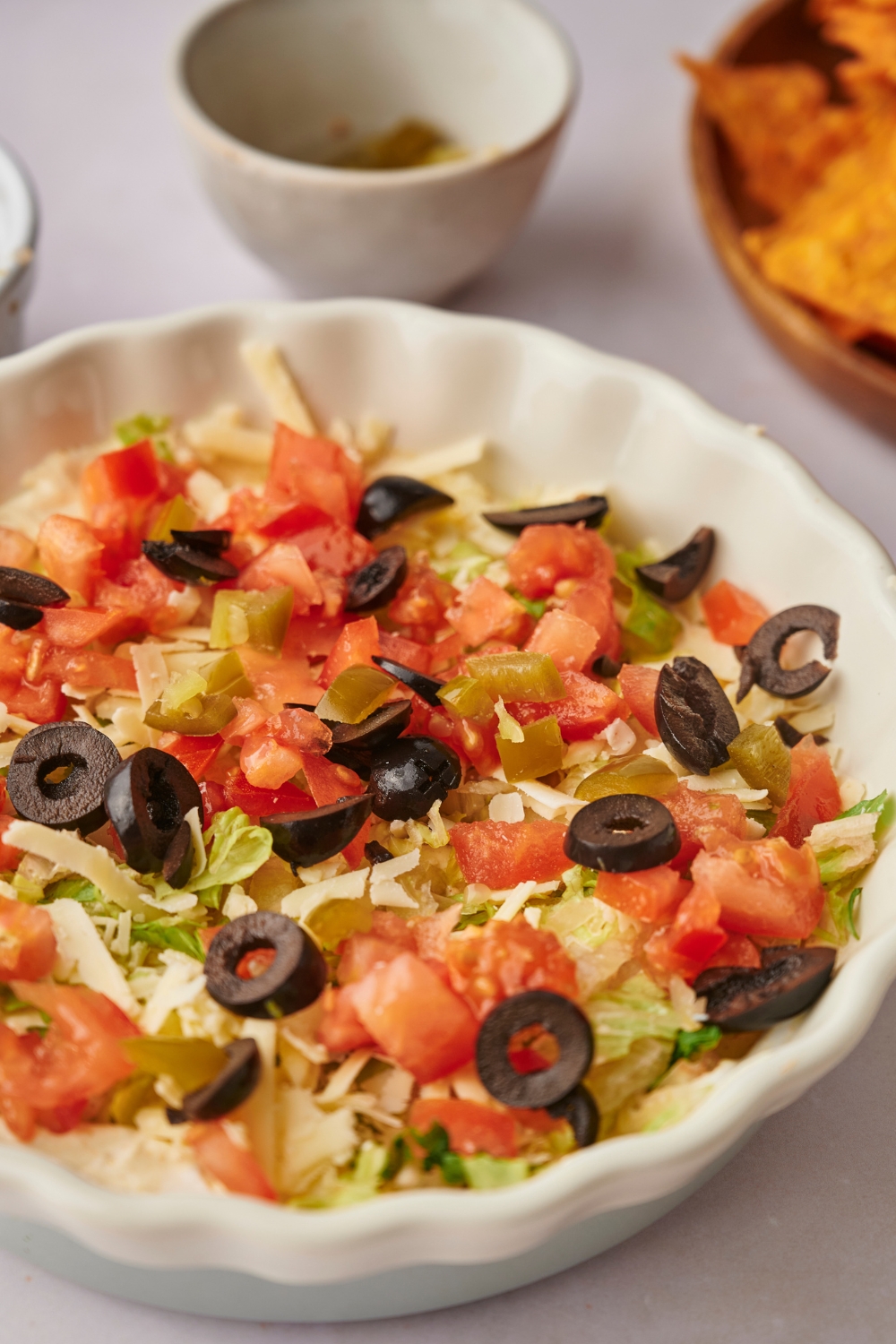 A serving dish with taco dip in it.