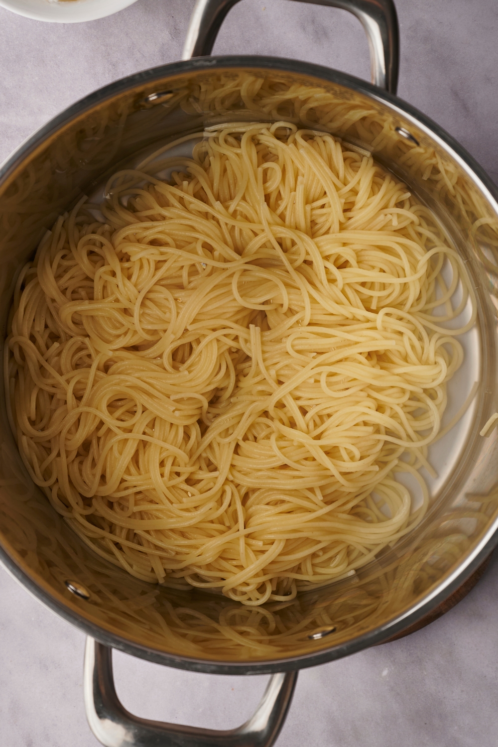 A deep pot with cooked spaghetti in it.