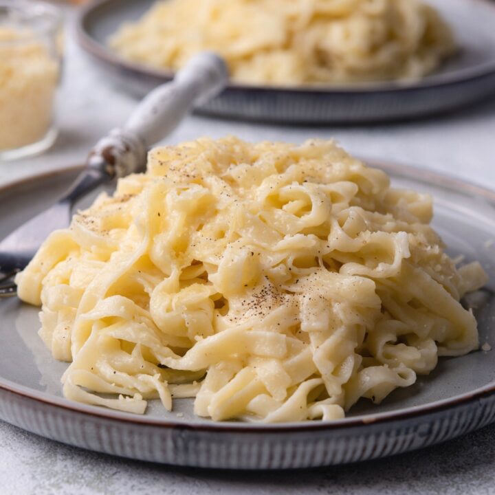 A pile of buttered noodles on a plate.