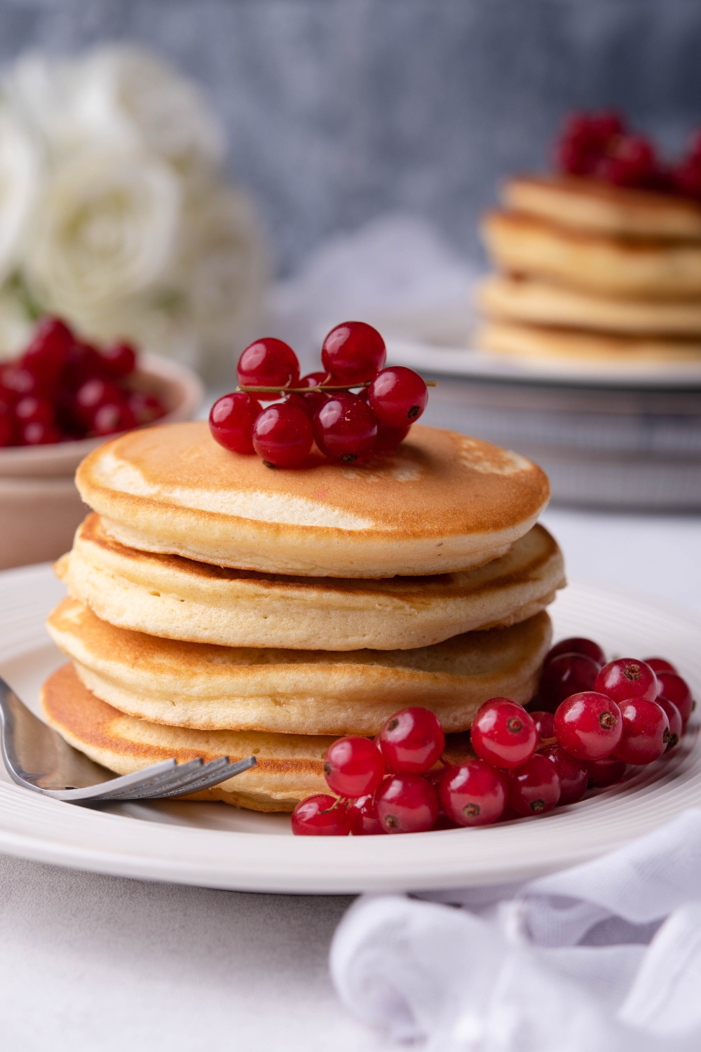 A stack of pancakes talked with grapes.