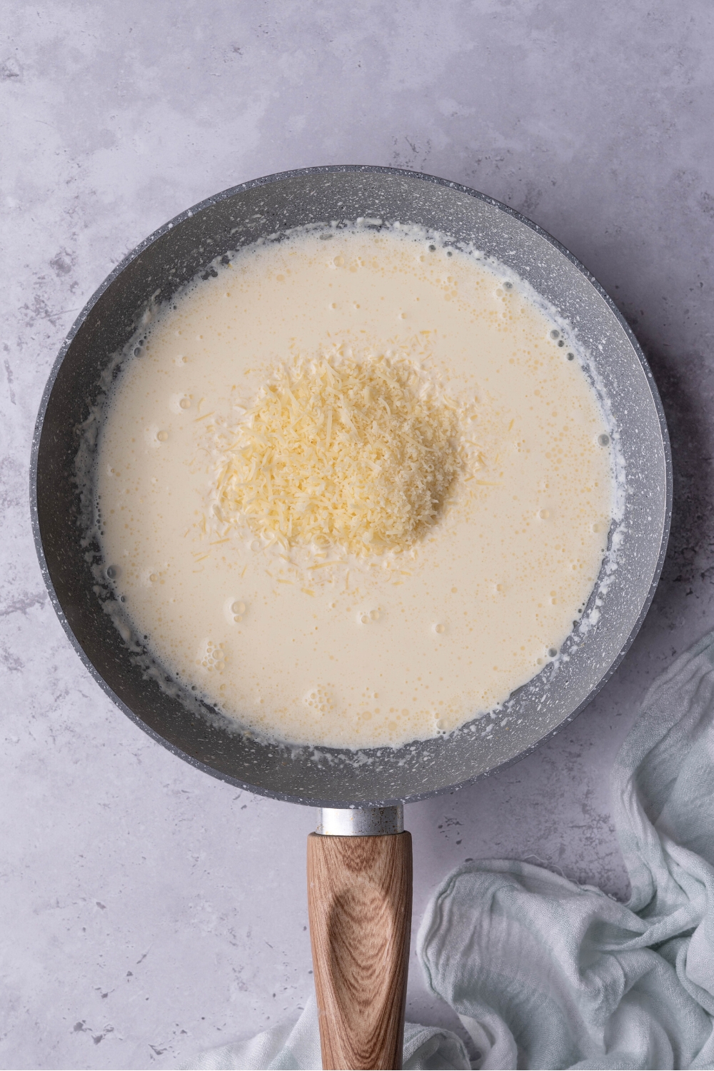 A mound of Parmesan cheese in a cream sauce in a pan.