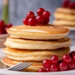 A stack of pancakes topped with fresh berries.