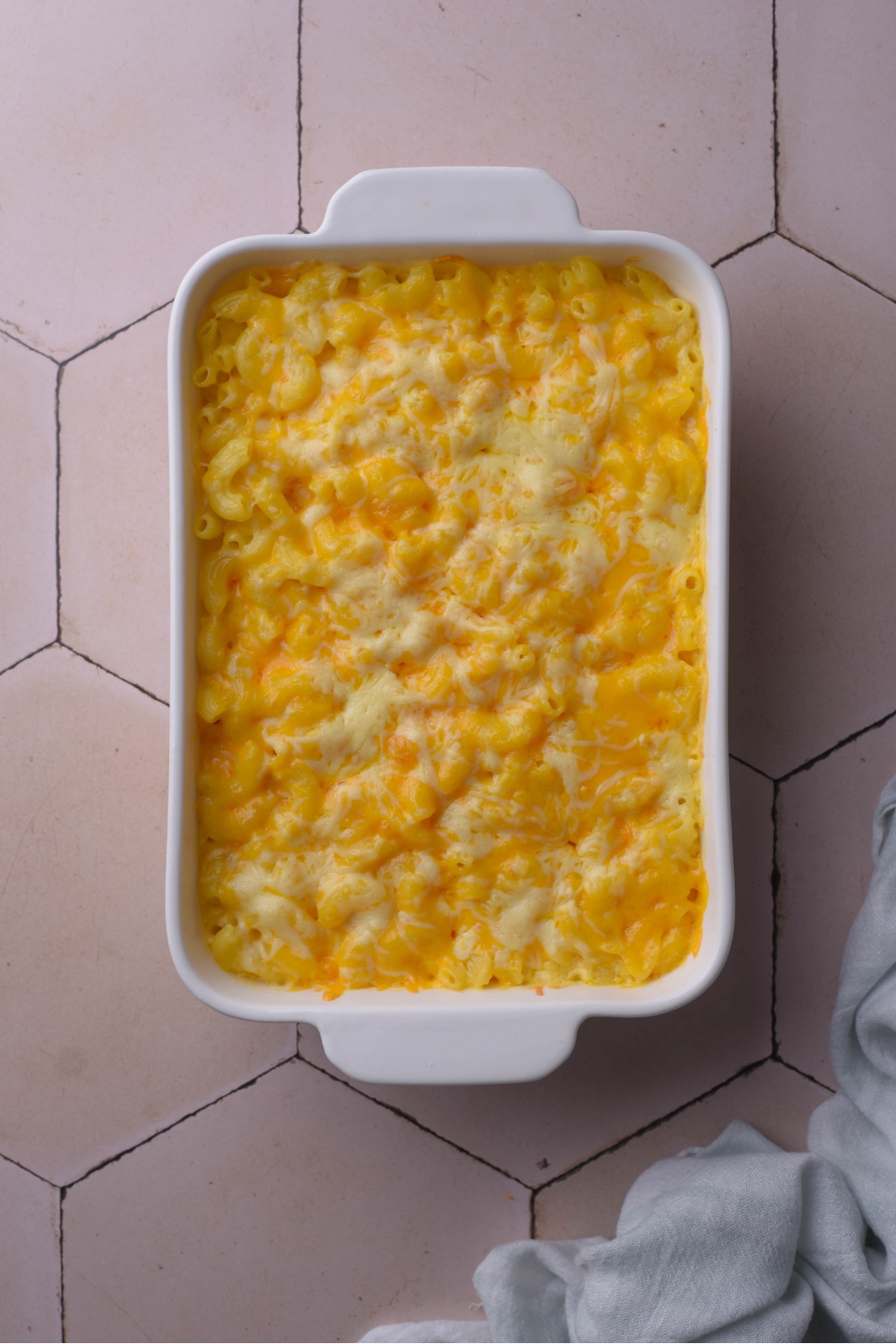 A white baking dish filled with freshly baked Chick Fil A mac and cheese with melted cheese on top.