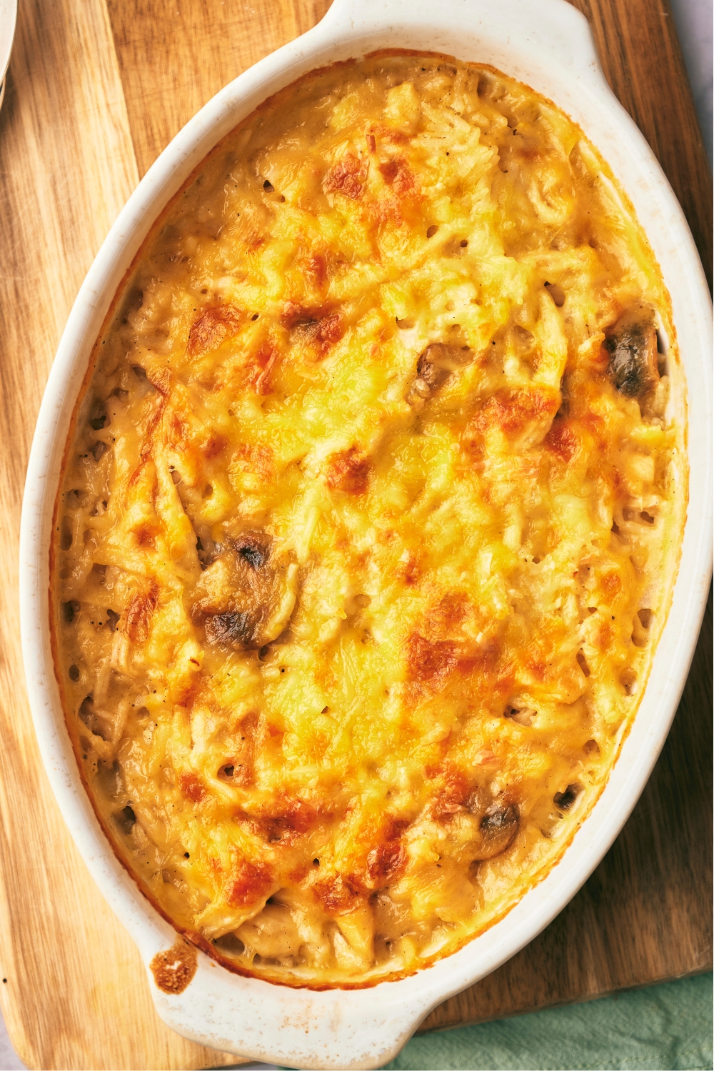 An overhead view of a casserole dish with baked cheesy chicken and rice casserole in it.