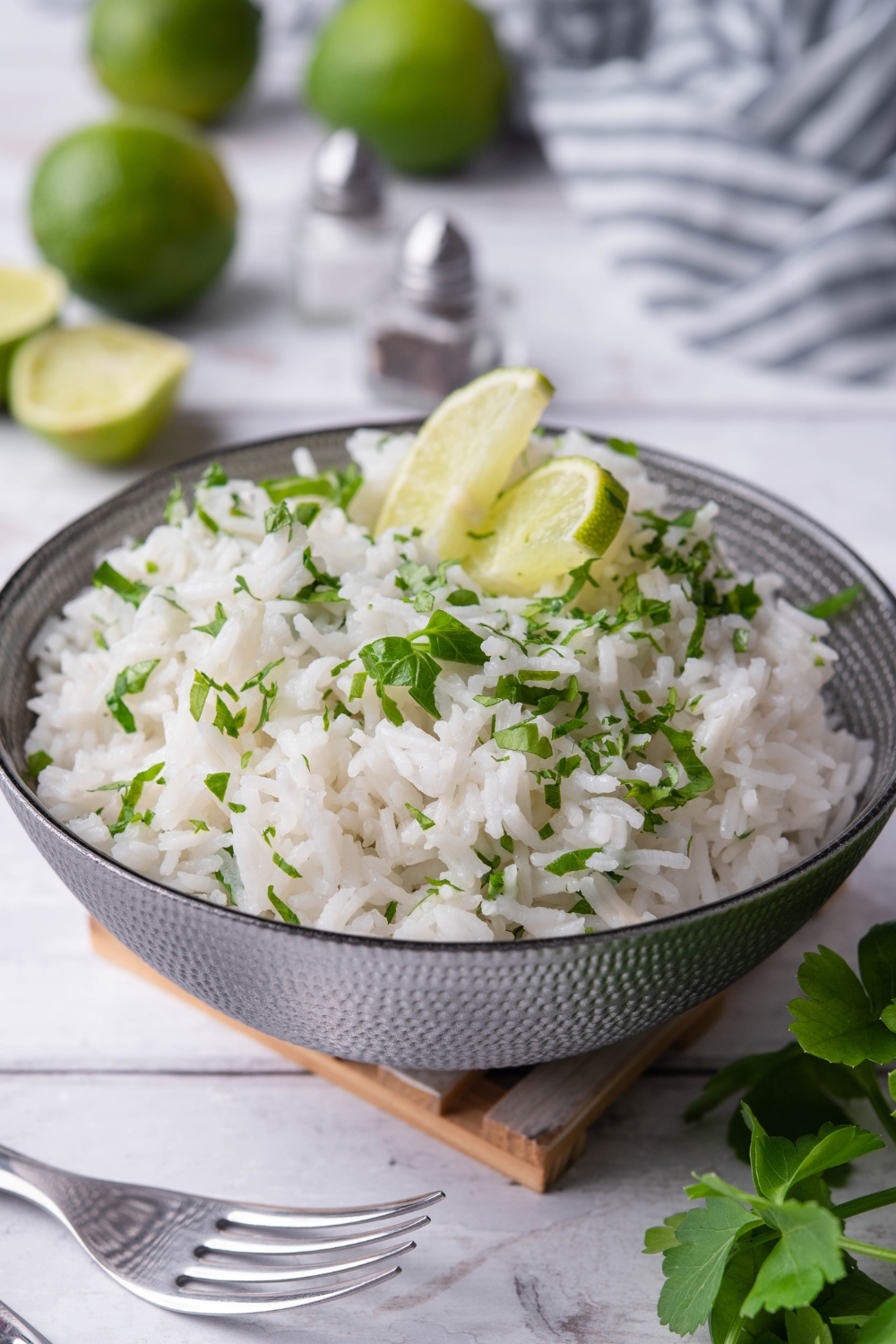 Two limes that are set on top of white rice in a bowl.