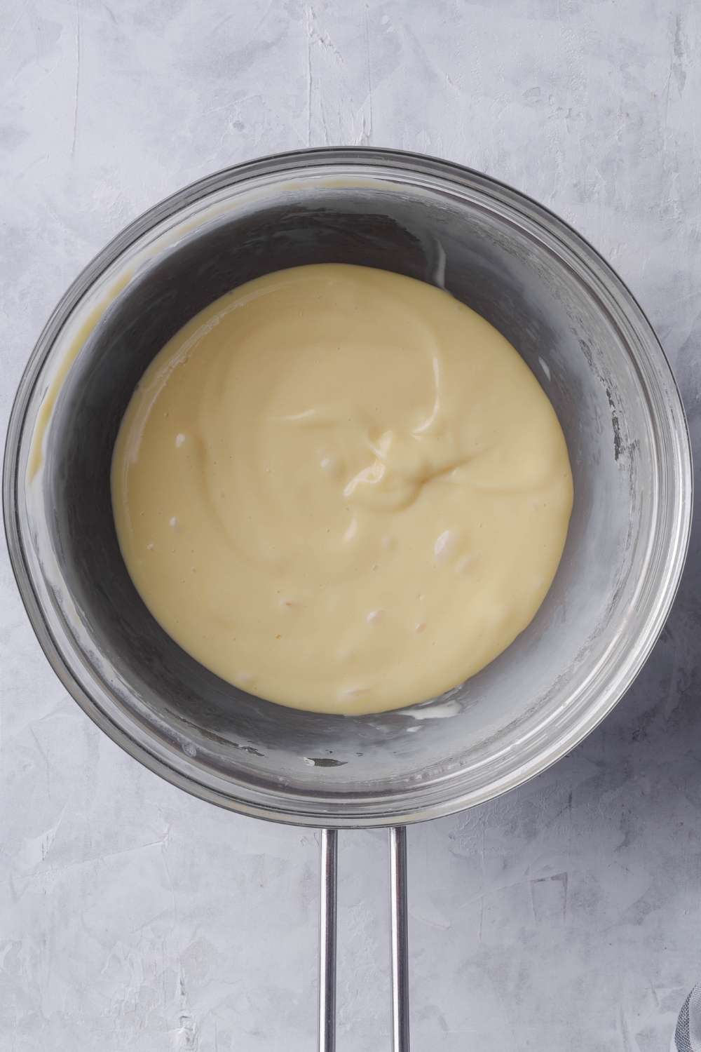 A double boiler with smooth creamy cheese.
