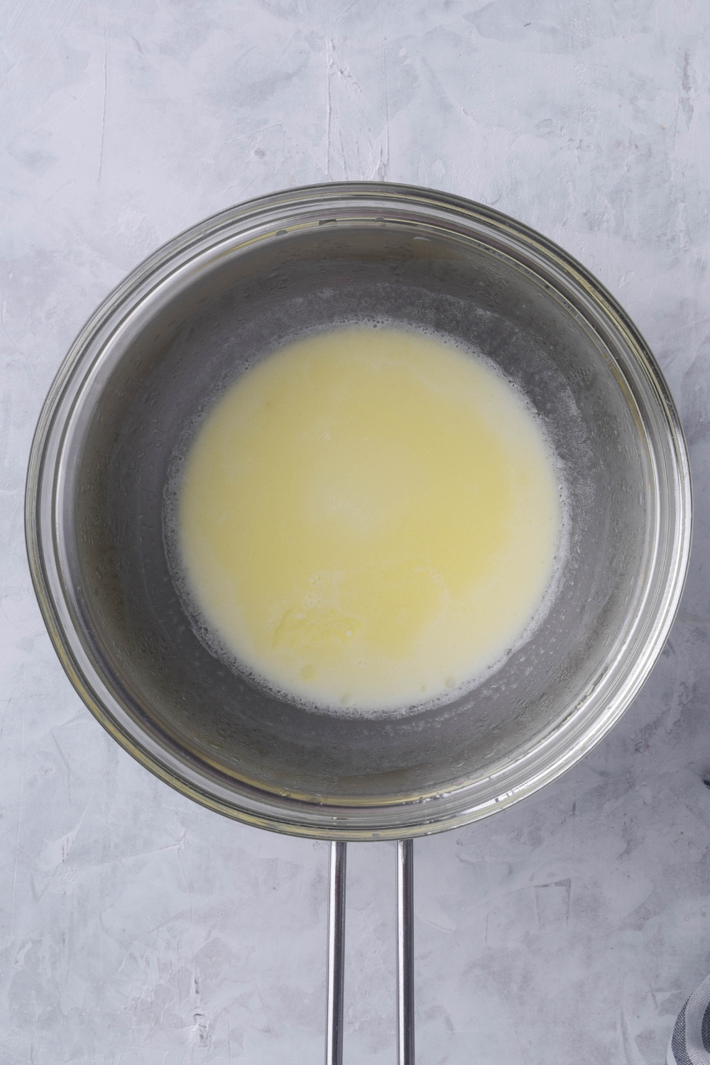 A double boiler with melted butter and milk.