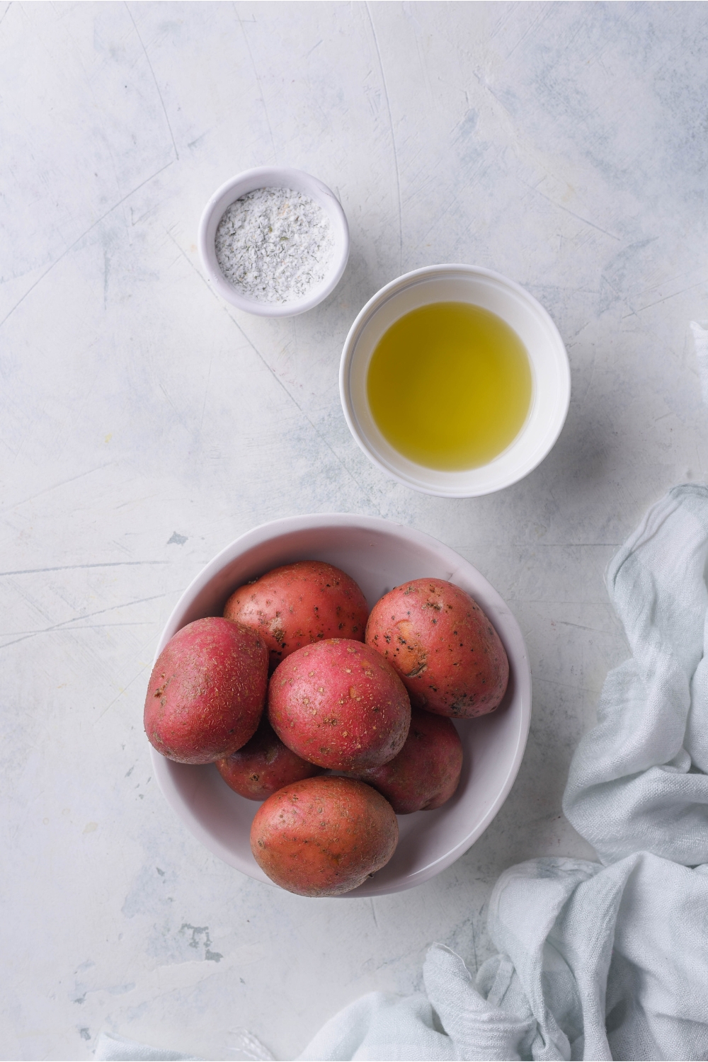 Bowls of red potatoes, oil, and ranch seasoning.