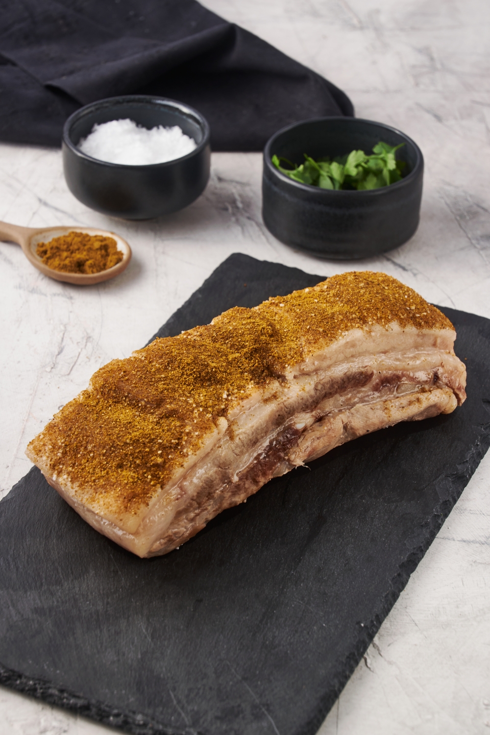 Cooked pork belly covered in a brown spice blend.
