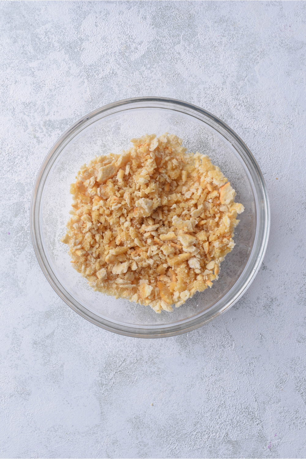 A clear bowl filled with cracker crumbs.
