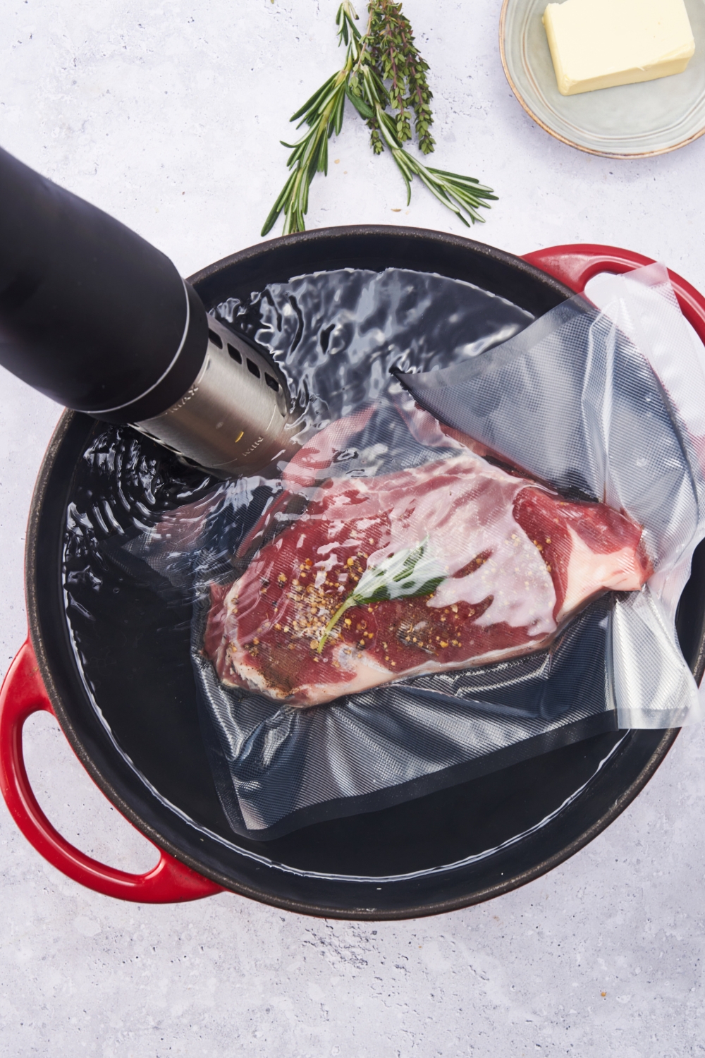 A steak inside a vacuum-sealed bag being sous vide in a water bath.