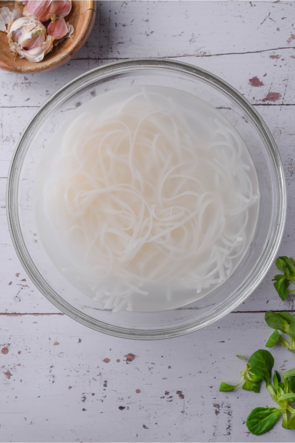 A bowl of rice noodles soaking in water.