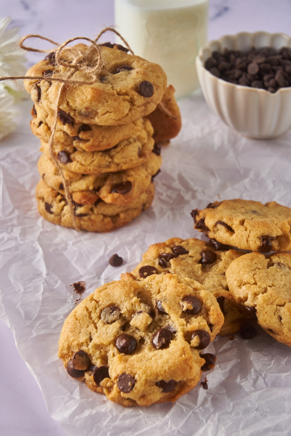 A pile of chocolate chip cookies and a neat stack of cookies tied together by twine.